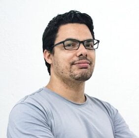 Mężczyzna z zarostem w okularach.