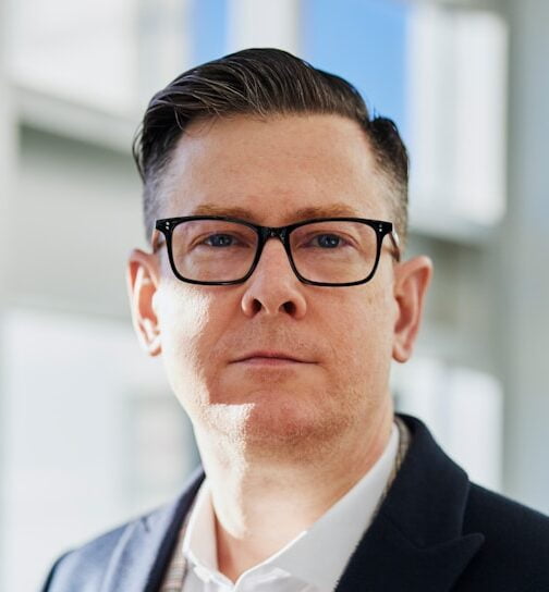 Mężczyzna w garniturze i w okularach.